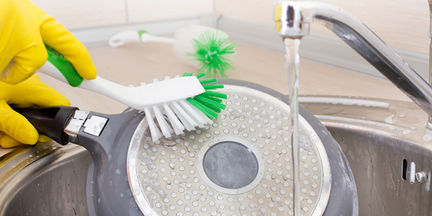 Woman cleaning frying pan