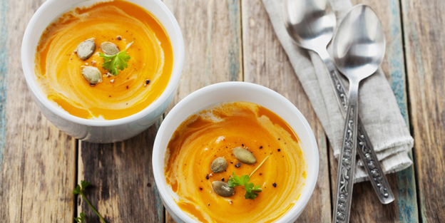 Fresh carrot or pumpkin soup in white bowl